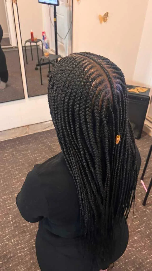 Person with braided hair in a salon setting