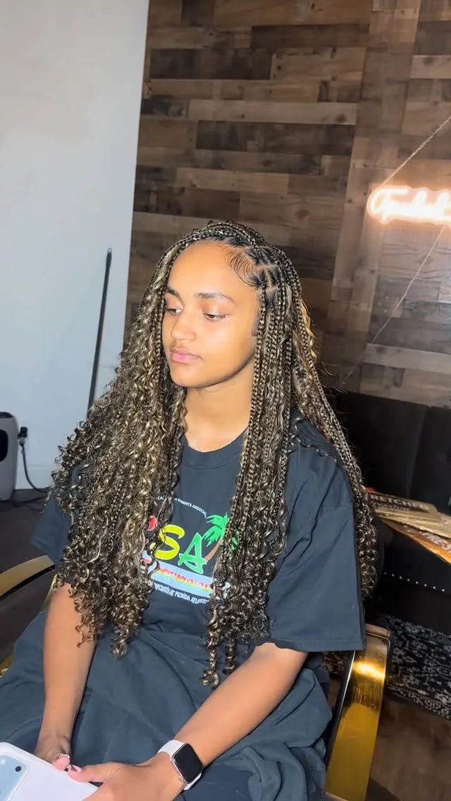 Long dark brown boho knotless braids with defined loose curls and a side-swept part, hairstylist located in Fort Lauderdale, FL