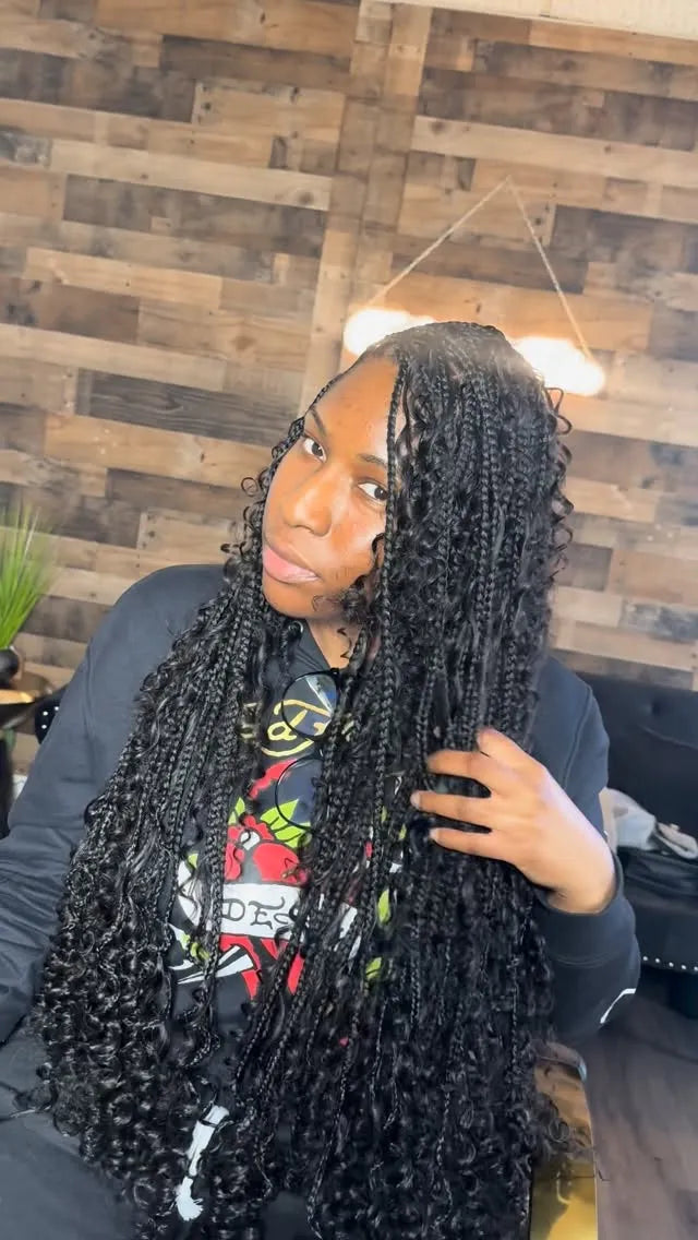 Long black curly crochet hairstyle with a middle part and soft wet-look waves, hairstylist located in Fort Lauderdale, FL