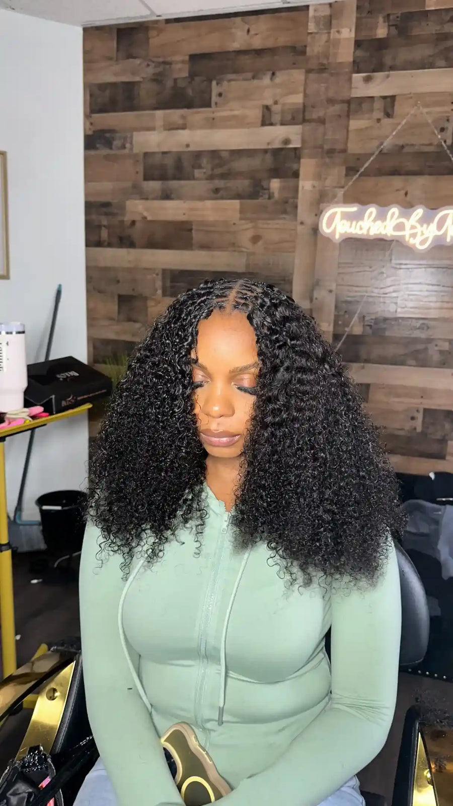 Shoulder-length curly crochet braids with a center part and full natural-looking volume, hairstylist located in Fort Lauderdale, FL