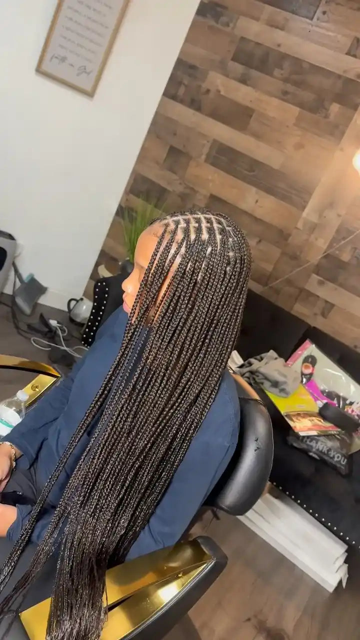 Long black boho braids with side cornrow detailing and loose curly ends, hairstylist located in Fort Lauderdale, FL