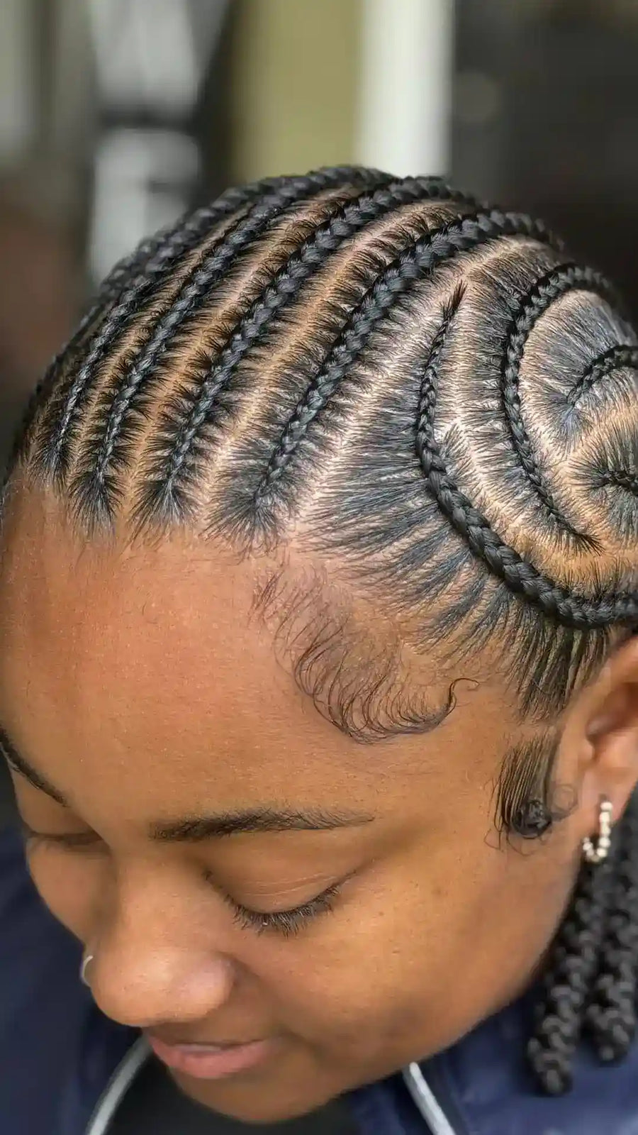 Curved stitch cornrows styled into a braided ponytail with a spiral side design, hairstylist located in Elba, AL