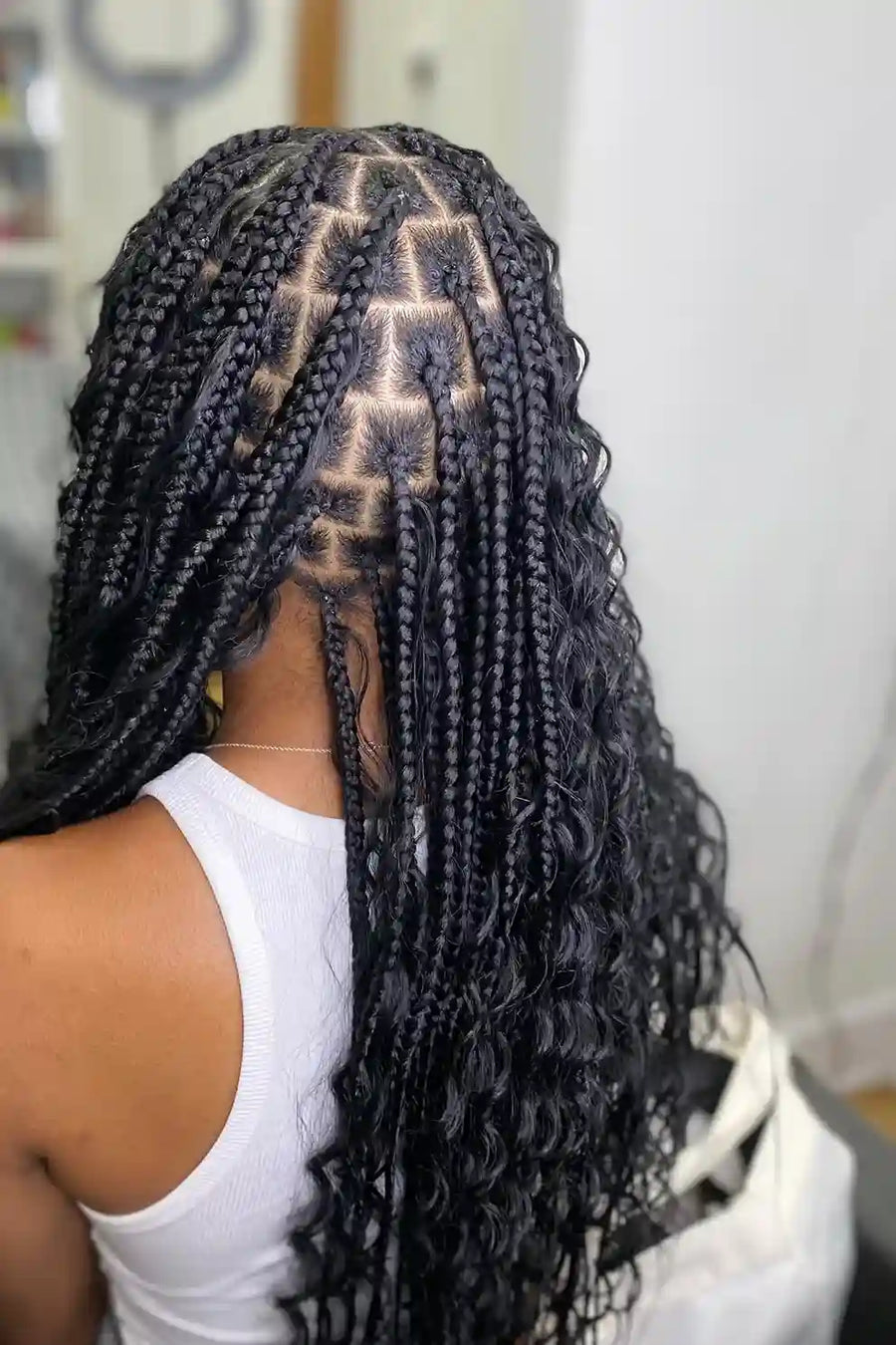 Person with intricately styled braided hair in a salon setting