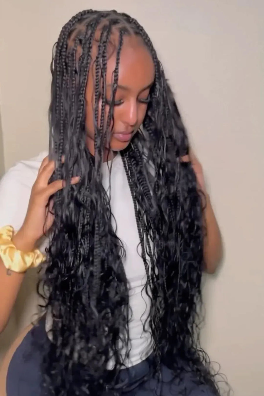 Woman with long braided hair against a plain background